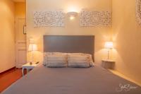 a bedroom with a large bed with two lamps at Le Relais Des Dentelles in Beaumes-de-Venise