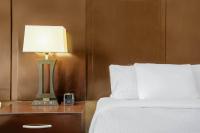 Una cama con una lámpara y un reloj en una mesita de noche. en La Quinta by Wyndham Conway, en Conway