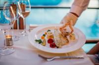 a plate of food on a table with wine glasses at Hotel Eden in Podstrana