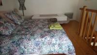 a bedroom with a bed with a flowered bedspread at Les Landes De Mauchat in Saint-Martin-de-Fressengeas
