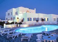 a swimming pool with white chairs and a building at Babis Hotel in Karterados
