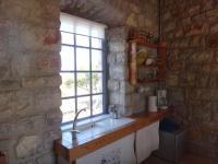 a kitchen with a sink and a window at Kastraki Art Houses in Kousounárion