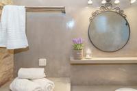 a bathroom with a mirror and towels on a shelf at Voulamandis House in Kambos