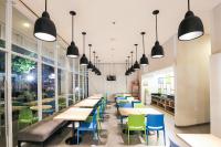 a cafeteria with tables and chairs and windows at Hotel Citradream Bandung in Bandung