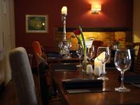 una mesa en un restaurante con copas de vino y flores en Recruiting Sergeant, en Norwich