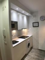 a kitchen with white cabinets and a washer and sink at Apartmento Apartaclub La Barrosa 223 in Chiclana de la Frontera
