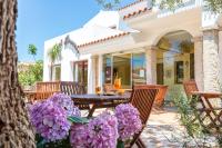 un patio con una mesa y flores púrpuras en Hotel Bonsai, en San Teodoro