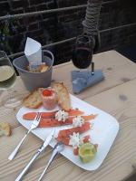 un plato de comida en una mesa con una copa de vino en la maison du phare DE HONFLEUR chambre d hôtes B&amp;B -jacuzzi privé- shabby chic, en Honfleur