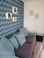 a living room with a couch with blue pillows at La Houle, maison classée 4 étoiles in Criel-sur-Mer