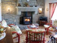 a living room with a stone fireplace and a table and chairs at Holiday Home Blaue Hortensie - SZN100 by Interhome in Sizun