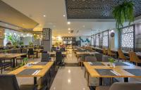 ein Restaurant mit Holztischen und -stühlen und Menschen darin in der Unterkunft Zenseana Resort & Spa - Patong, Phuket in Patong Beach