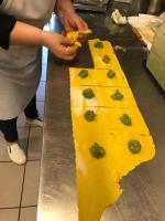 a person cutting a piece of food on a counter at Albergo Locanda Primavera in Rodengo Saiano