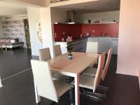 a kitchen and dining room with a wooden table and chairs at Panorama Apartman in Velence