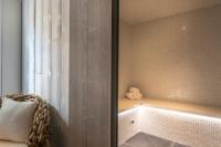 a bathroom with a bath tub with a window at The Originals Boutique La Villa Ouest &amp; Spa in Saint-Palais-sur-Mer