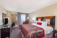 ナショナル・シティにあるRamada by Wyndham San Diego National Cityのベッドと机とテレビがあるホテルの部屋