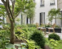 a garden with two chairs and a table at Maison Albar - Le Vendome in Paris