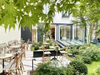 a restaurant with wooden chairs and tables in a garden at Maison Albar - Le Vendome in Paris
