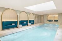 a swimming pool in a hotel room with blue furniture at Maison Albar - Le Vendome in Paris