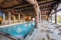 an indoor pool in a building with lounge chairs at Résidence Pierre &amp; Vacances Premium Les Alpages de Chantel in Arc 1800