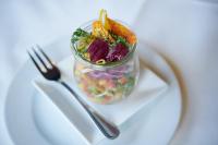 Un frasco de ensalada en un plato blanco con un tenedor. en Hotel Bannwaldsee, en Halblech