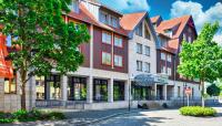 un edificio en una calle con un árbol en HKK Hotel Wernigerode, en Wernigerode