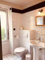 a white bathroom with a toilet and a sink at Hôtel Le Cobh in Ploërmel