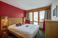 a bedroom with a bed and a large window at Résidence Pierre &amp; Vacances Les Néréides in Belle Plagne