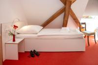 a white bed in a room with a vase of flowers at Gästehaus Reckahn der Rochow Akademie in Reckahn