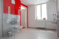 a bathroom with a toilet and a red wall at Gästehaus Reckahn der Rochow Akademie in Reckahn