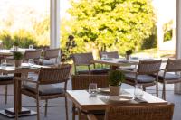 un grupo de mesas y sillas en un restaurante en Skiathos Avaton Hotel, Philian Hotels & Resorts, en Skiathos