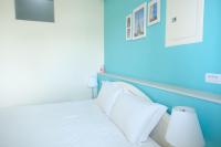 a bedroom with blue walls and a bed with white pillows at Bonjour, Paris in Taitung City
