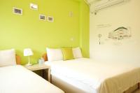 two beds in a room with green walls at Bonjour, Paris in Taitung City