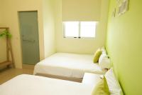 a small room with two beds and a window at Bonjour, Paris in Taitung City