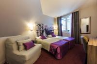 a hotel room with two beds and a couch at Hôtel Harvey in Paris