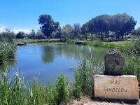 a pond with a sign that reads mass farmland at Mas Fandelou in Saintes-Maries-de-la-Mer