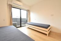 Un dormitorio con una cama y una ventana grande. en Enzo Chidoribashi, en Osaka