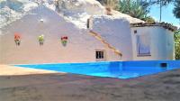 a small house with flowers on the side of it at Casa Cueva “La Estrella” in Granada