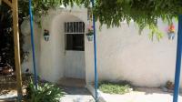 a white building with a door with flowers on it at Casa Cueva “La Estrella” in Granada