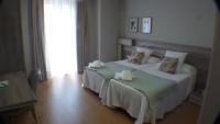 A bed or beds in a room at Hotel Roquiño