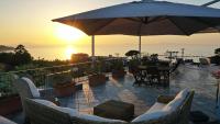 Un patio con sillas y una sombrilla y una mesa. en Sea&Skyview, en Sorrento