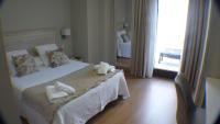 A bed or beds in a room at Hotel Roquiño
