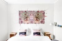 Un dormitorio con una cama con un cuadro en la pared. en Lille Hotell, en Arendal