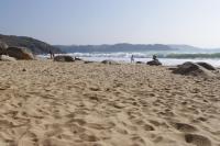 a sandy beach with people walking on the beach at Chambres d&#39;hôtes Air Marin in Lannion