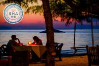 Un hombre y una mujer sentados en una mesa en la playa en Am Samui Resort Taling Ngam, en Taling Ngam