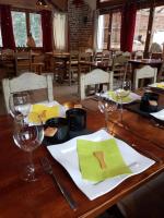 een houten tafel met borden en wijnglazen erop bij Auberge Refuge de Roybon in Saint-Martin-en-Vercors