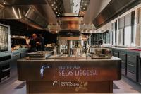 a large kitchen with a counter in a kitchen at Van Der Valk Sélys Liège Hotel &amp; Spa in Liège