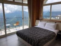 a bedroom with a bed and a balcony with windows at Star Villa in Ren&#39;ai