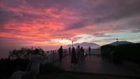 a group of people standing on a balcony watching the sunset at Star Villa in Ren&#39;ai