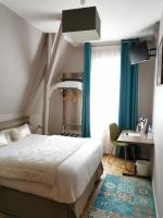 a bedroom with a bed and a desk and a window at Hotel Eden in Béthune