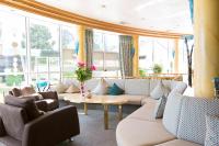 Una sala de estar con sofás, una mesa y ventanas. en AKZENT Hotel Restaurant Altdorfer Hof, en Weingarten